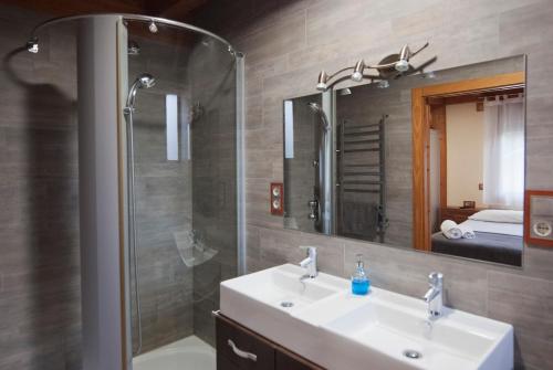 a bathroom with a sink and a shower and a mirror at Can Congost in Sort