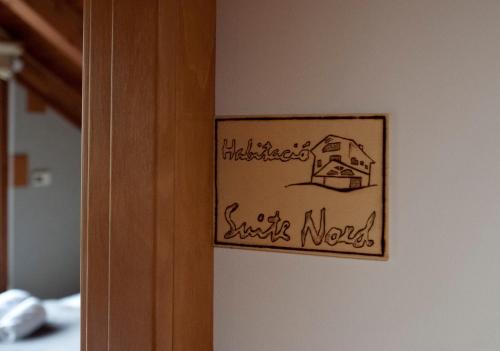 a sign on a wall with a house on it at Can Congost in Sort