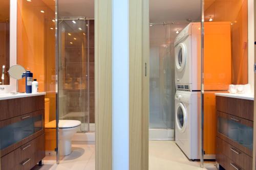 a bathroom with a toilet and a washer and dryer at Lux Aigle "Acceso directo a pistas" in Pas de la Casa