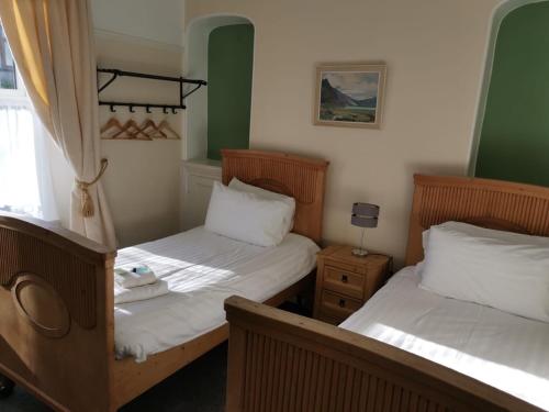 2 camas en una habitación con verde y blanco en Mairs Bed and Breakfast. en Bridgend
