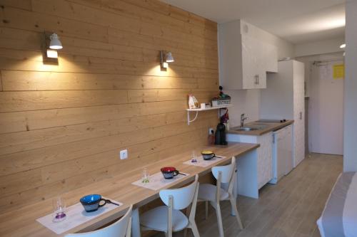 - une cuisine avec des murs en bois et 2 tables et chaises dans l'établissement Studio 116, à Carquefou