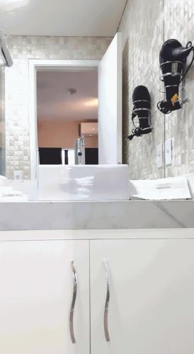 a bathroom with a white sink and a mirror at DUPLEX 5 min de Alphaville in Barueri