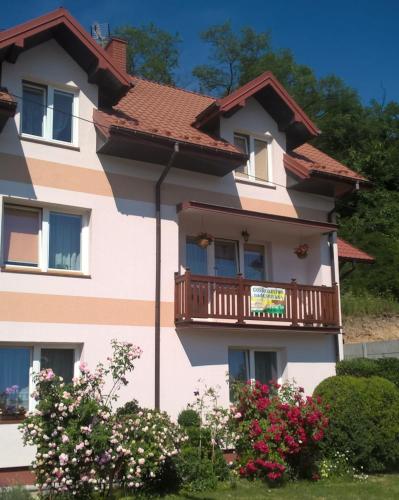 a pink building with a balcony on it at Gospodarstwo agro Nad Kamienną in Bałtów