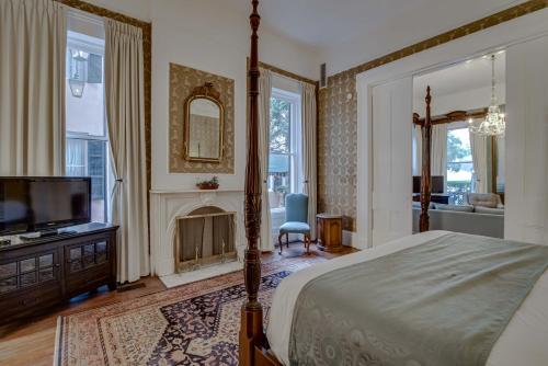 a bedroom with a bed and a tv and a fireplace at Malaga Inn in Mobile