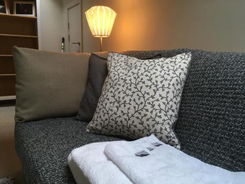 um sofá com uma almofada e uma toalha em Stylish City Centre Flat em Leeds