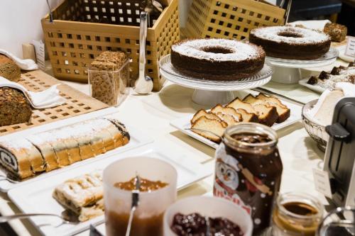 a table with cakes and other pastries and desserts at Hotel Kapeller Innsbruck in Innsbruck