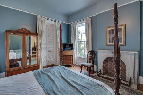 a bedroom with a bed and a fireplace at Malaga Inn in Mobile