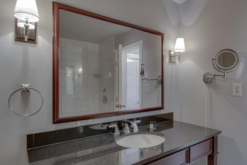 a bathroom with a sink and a large mirror at Malaga Inn in Mobile