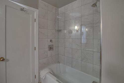 a white bathroom with a tub and a shower at Malaga Inn in Mobile