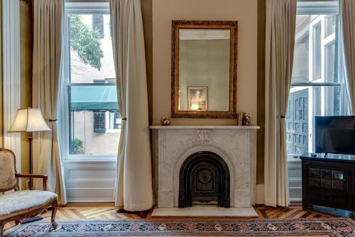 a living room with a fireplace and a mirror at Malaga Inn in Mobile