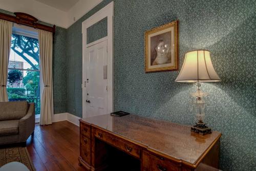 a living room with a desk with a lamp on it at Malaga Inn in Mobile