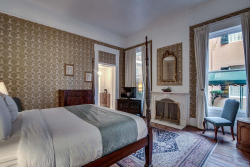 a bedroom with a bed and a fireplace at Malaga Inn in Mobile