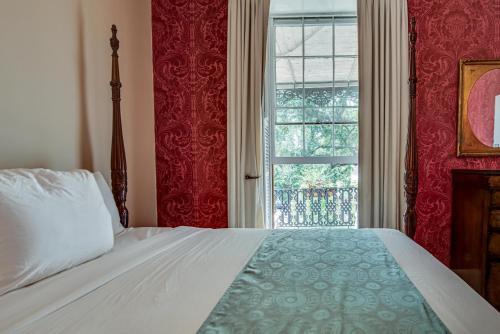 a bedroom with a bed and a window at Malaga Inn in Mobile
