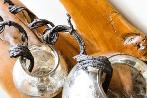 two glass vases with handles on a wooden tray at Hotel Kapeller Innsbruck in Innsbruck