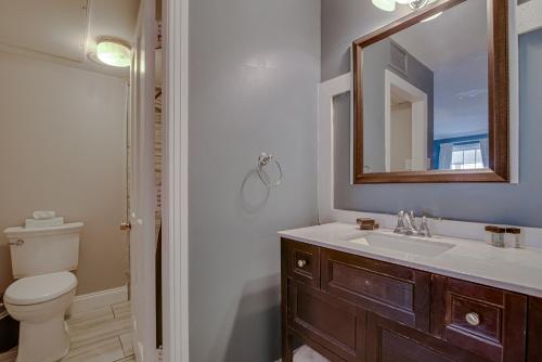a bathroom with a sink and a toilet and a mirror at Malaga Inn in Mobile