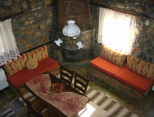 a living room with a couch and a table and a window at Traditional Villas in Old Agios Athanasios in Palaios Agios Athanasios