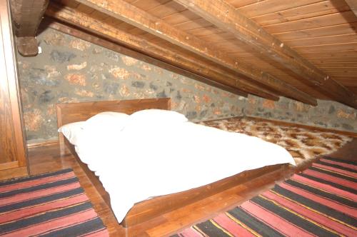 a bedroom with a bed with white sheets on it at Traditional Villas in Old Agios Athanasios in Palaios Agios Athanasios