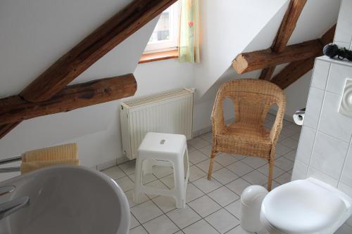 La salle de bains est pourvue de toilettes et d'une chaise. dans l'établissement Hotel zum Brauhaus, à Quedlinbourg