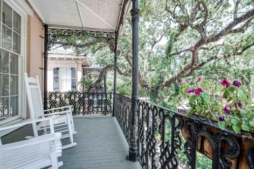 a porch with a white bench and a tree at Malaga Inn in Mobile