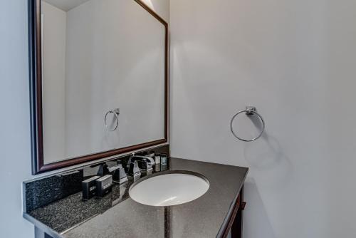 a white sink sitting under a mirror in a bathroom at Malaga Inn in Mobile