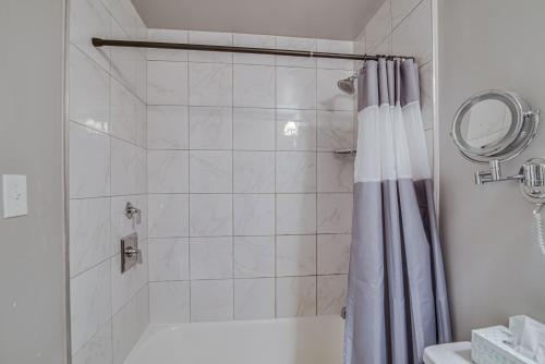 a bathroom with a shower with a shower curtain at Malaga Inn in Mobile