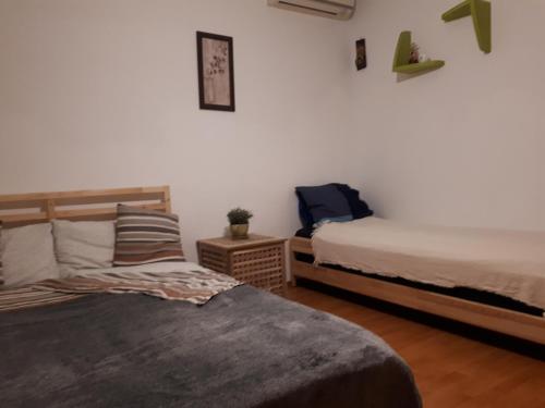 een slaapkamer met 2 bedden en een stoel bij 2H Apartment in Boekarest