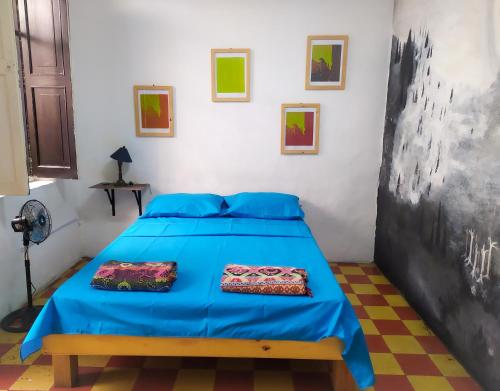 a bedroom with a blue bed with two pillows on it at JEP Hostel in Medellín