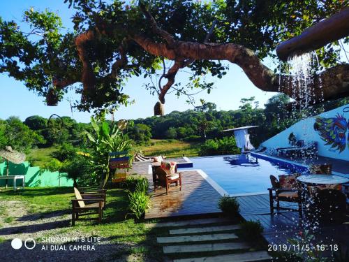 un patio trasero con piscina y un árbol en Villa Nobre Diniglei, en Trancoso
