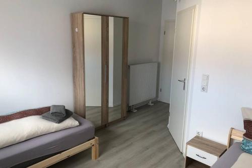 Habitación pequeña con cama y espejo. en Zimmer 3 en Alzenau in Unterfranken
