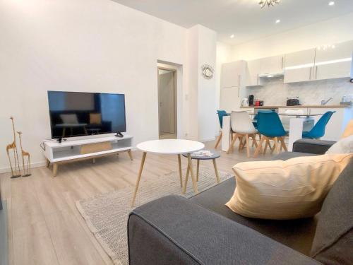 a living room with a couch and a flat screen tv at Deluxe Design - City Center Cosy Apartments in Colmar