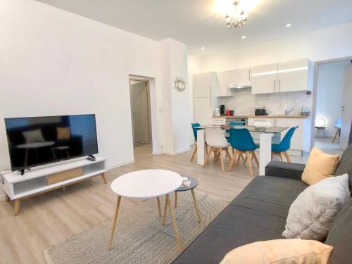 a living room with a couch and a tv and a table at Deluxe Design - City Center Cosy Apartments in Colmar