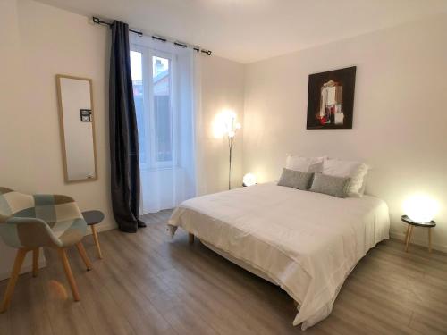 una camera da letto con un grande letto bianco e una finestra di Deluxe Design - City Center Cosy Apartments a Colmar