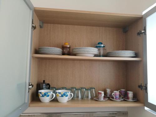 a cupboard with plates and cups and dishes in it at Casa Bianca in Marina di Massa