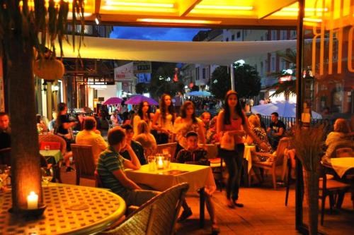 a group of people sitting at tables in a restaurant at Erlebnis Post - Stadthotel mit EigenART in Spittal an der Drau
