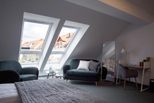 a bedroom with a bed and a chair and a mirror at Hotel & Restaurant Am Alten Rhin in Neuruppin
