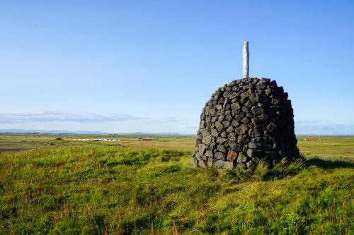 a large rock sitting on top of a grass covered field at Camp Boutique in Gaulverjabær