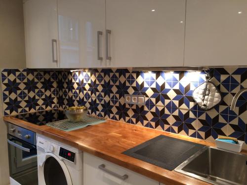 - une cuisine avec du carrelage noir et blanc sur le mur dans l'établissement Le petit bourgeois de Nice, à Nice