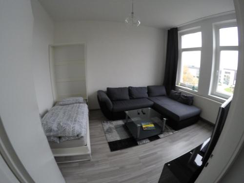 ein Wohnzimmer mit einer Couch und einem Bett in der Unterkunft Clean & Central 2 Room Apartment 50m² in Hannover