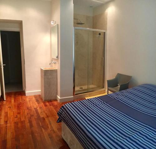 - une chambre avec une douche, un lit et du parquet dans l'établissement Le petit bourgeois de Nice, à Nice