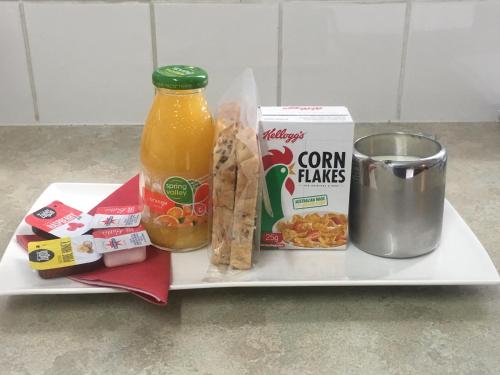 a plate of food with a bottle of orange juice and some food at Comfort Inn Western in Warrnambool