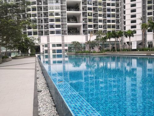 une piscine en face d'un grand bâtiment dans l'établissement Dz Studio and Suite Parisien Tower i-City, à Shah Alam