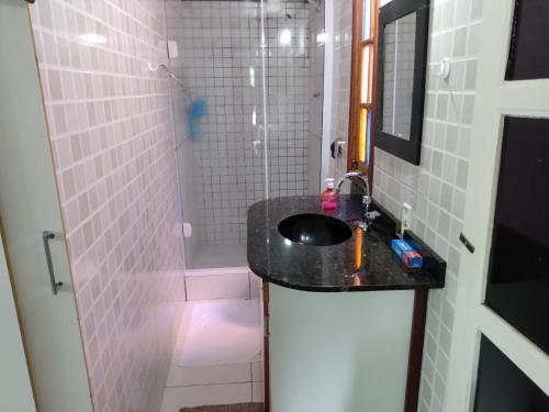 La salle de bains est pourvue d'un lavabo et d'une douche. dans l'établissement Loft Santos Dumont, à Nova Friburgo