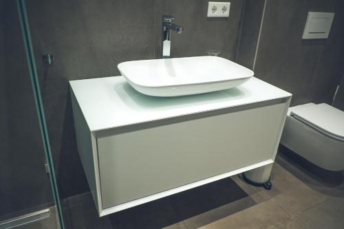 a bathroom with a white sink and a toilet at Stylisch eingerichtete Wohnung mitten in München! in Munich