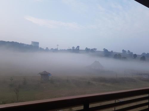 a foggy field with a gazebo in the middle at Apartment GEA 24 Zlatibor sa garažom in Zlatibor