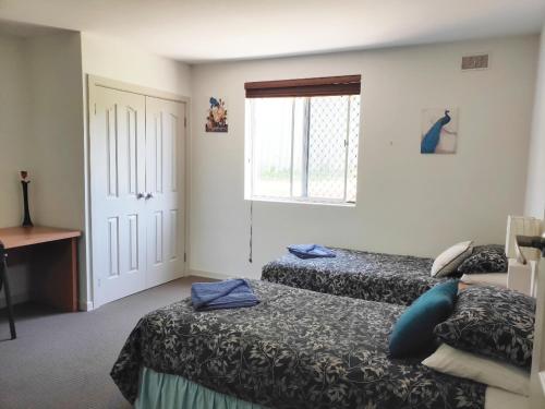 Habitación de hotel con 2 camas y ventana en Balcatta Sanctuary, en Perth