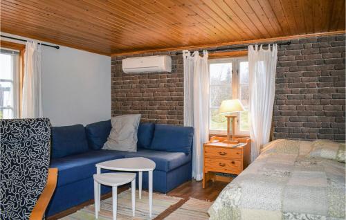 a living room with a blue couch and a bed at Awesome Home In Ambjörnarp in Ambjörnarp