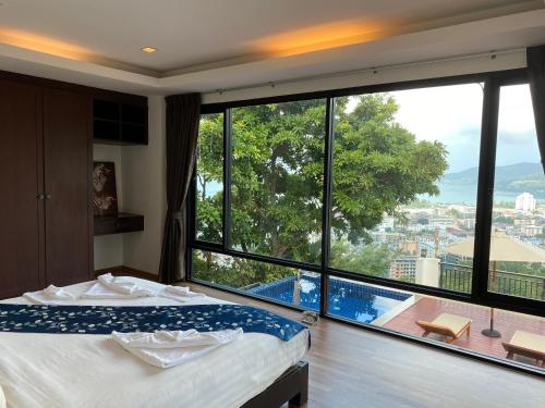 Sunset Bay View Phuket في شاطيء باتونغ: غرفة فندقية بسرير ونافذة كبيرة