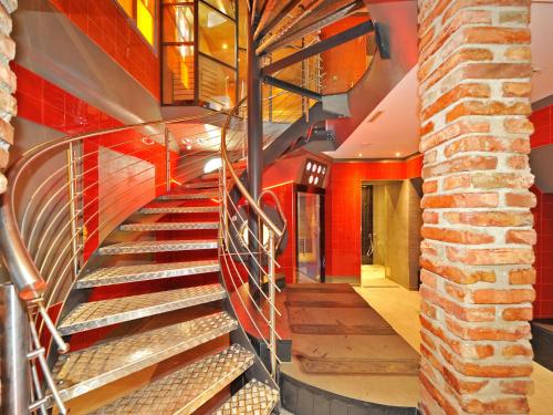a spiral staircase in a building with a brick wall at Erlebnis Post - Stadthotel mit EigenART in Spittal an der Drau