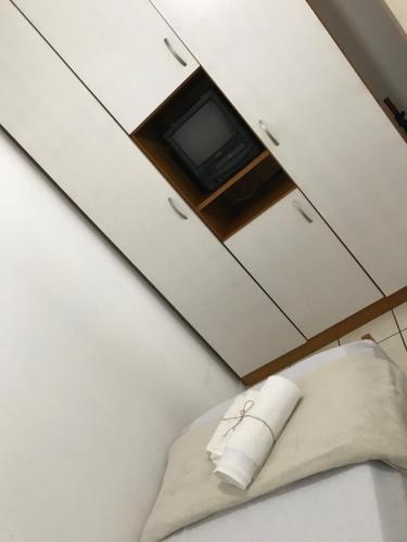 a white cabinet with a tv and a pillow at Apto Cond Ilhas do Caribe - Pr - Beira Mar in Matinhos