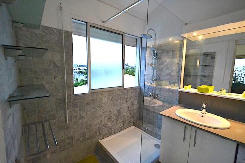 een badkamer met een wastafel en een douche bij Appartement Althéa in Le Gosier